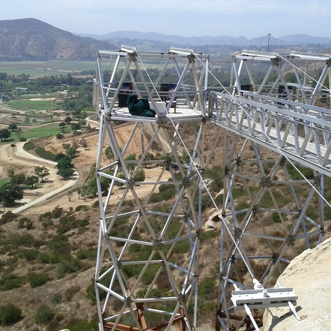 Estructura metálica con vista a un paisaje montañoso cubierto de vegetación.